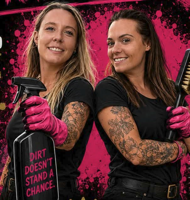 Maria and Sophie of Grime to Glory, back to back in pink cleaning gloves, holding a spray bottle and scrubbing brush
